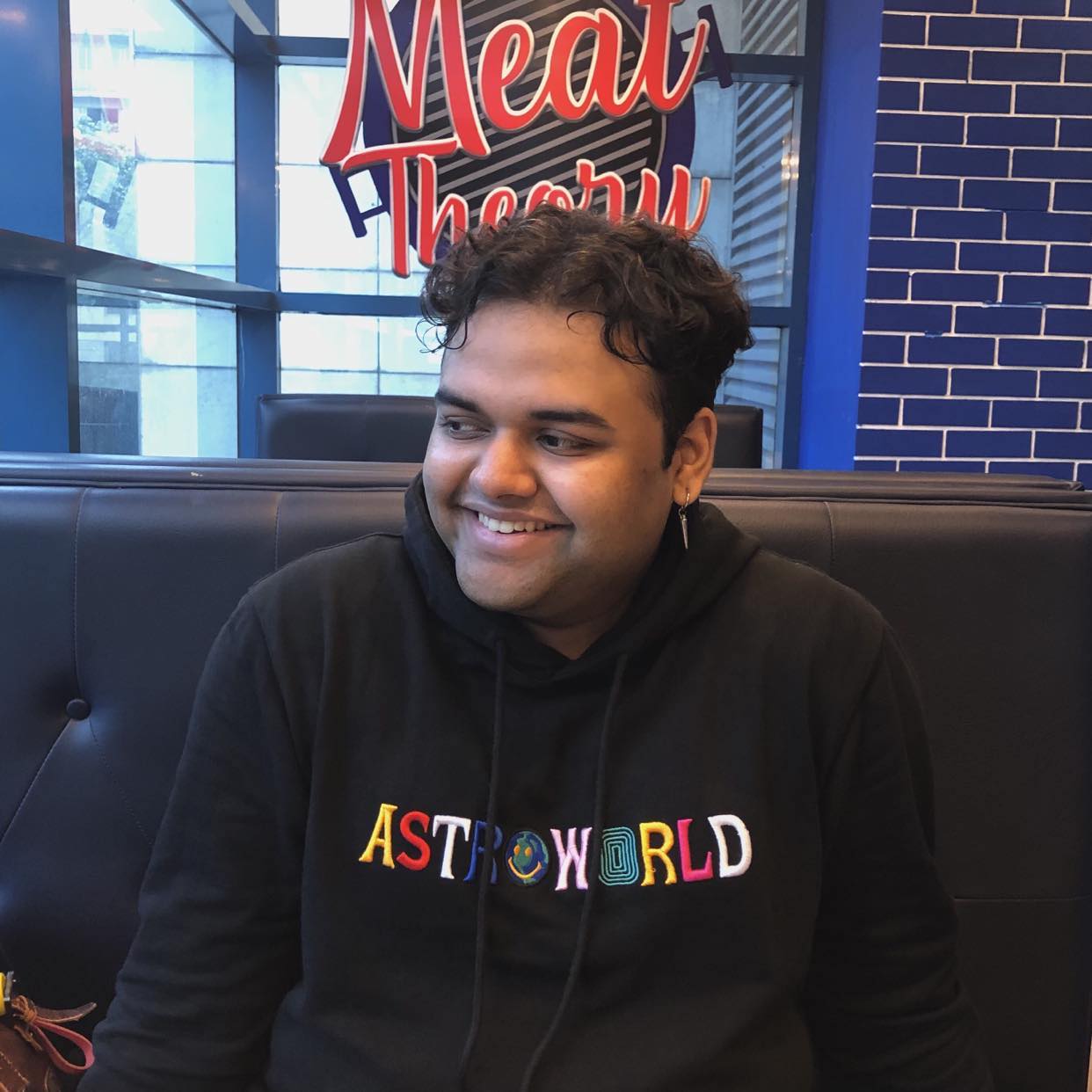 Rajin Khan smiling in a black hoodie